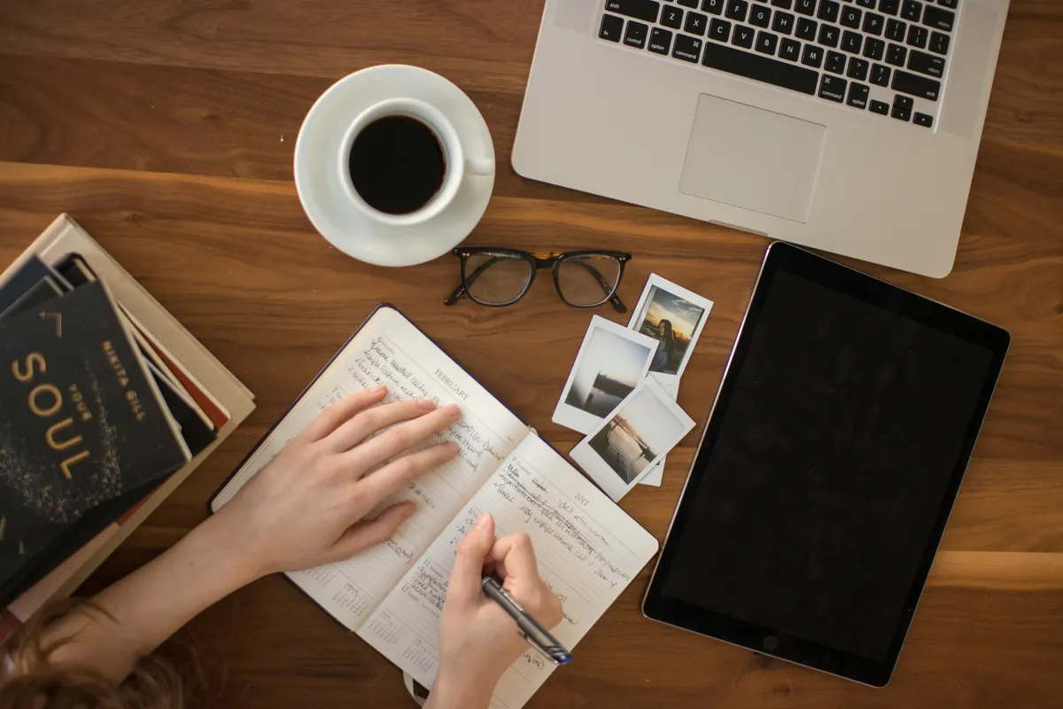 Escritorio con agenda, café y cuaderno de planeación
